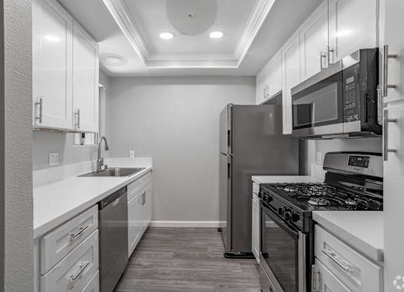 an empty kitchen with a wood floor and white walls at Lincoln Park Apartments, Corona, 92882
