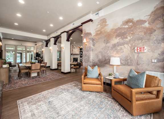 A living room with a large rug and a painting on the wall.