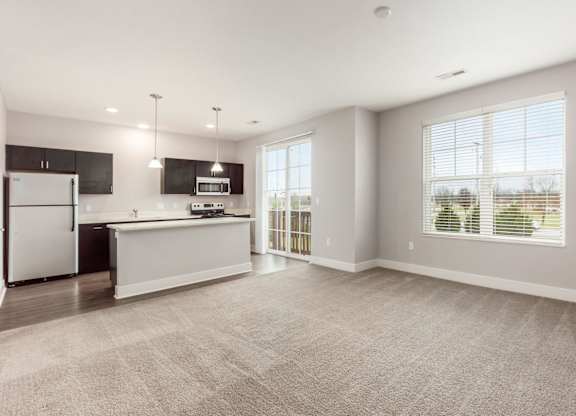 A spacious kitchen with a refrigerator, microwave, and oven.