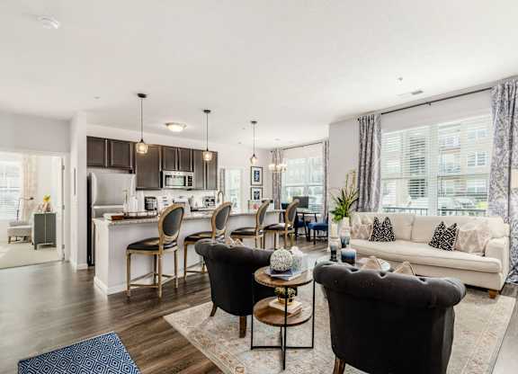 A modern living room with a kitchen in the background.