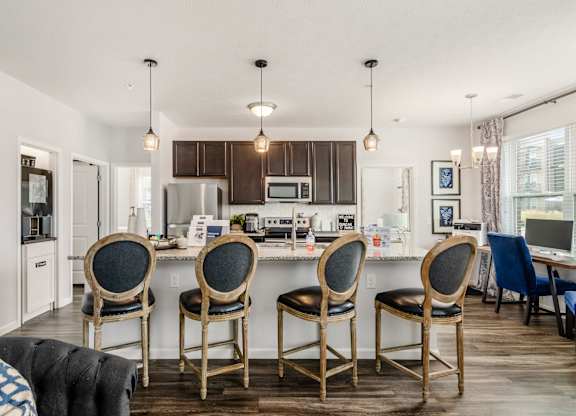 A kitchen with a table and chairs in front of it.