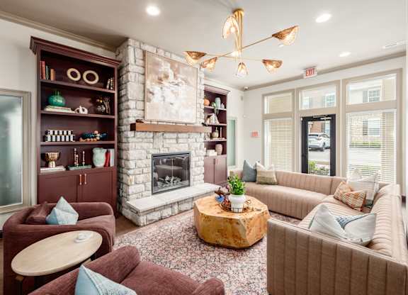 A living room with a fireplace and a large painting above it.