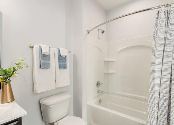 A white bathroom with a toilet, sink, and bathtub.