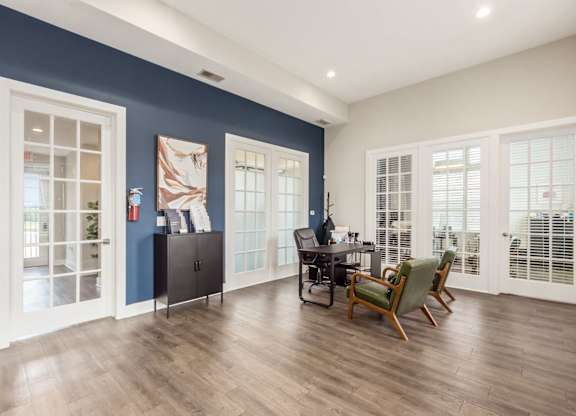 A room with a desk and chairs in it.