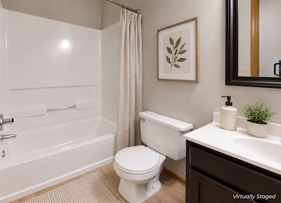 A white bathroom with a toilet, sink, and bathtub.