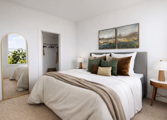 A bedroom with a large bed and a painting on the wall.