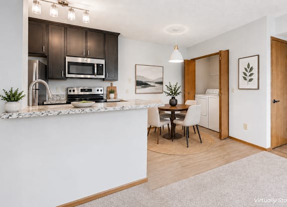 A kitchen with a white counter and brown cabinets.