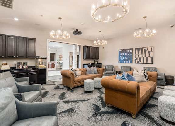 A living room with a brown sofa and grey armchairs.