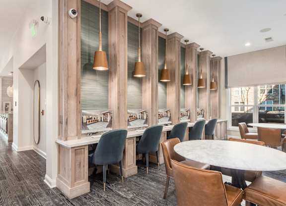 A dining room with a long table surrounded by chairs.