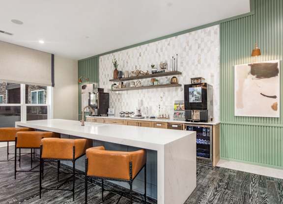 A bar area with a white counter and orange chairs.
