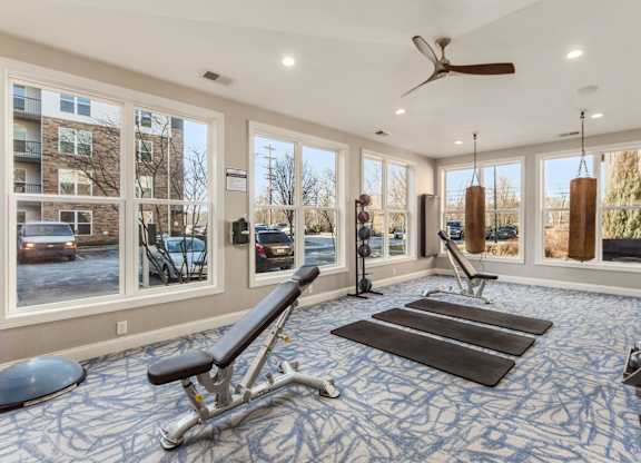 A spacious gym with a variety of equipment including a bench press, a rowing machine, and a treadmill.