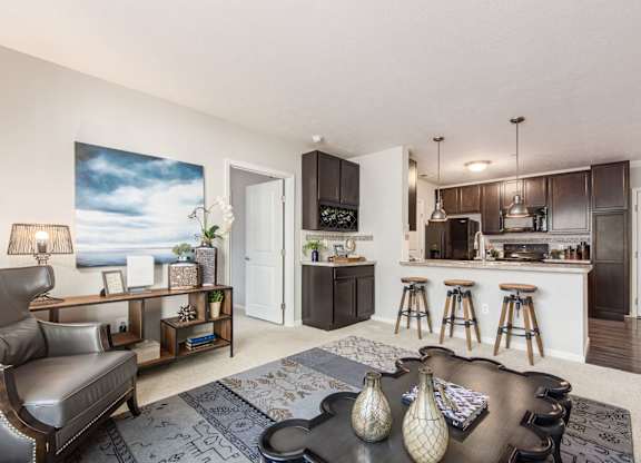 A modern living room with a bar area and a kitchen in the background.