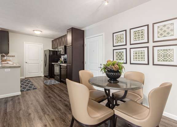 A dining room with a table and chairs.