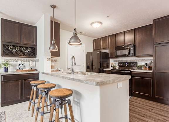 A kitchen with a white countertop and dark brown cabinets.