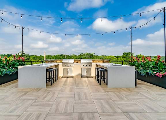 A modern outdoor kitchen with a bar area and seating.