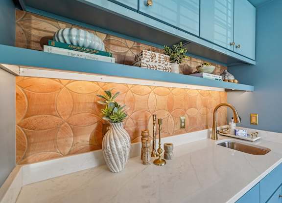 A kitchen with a white countertop and blue cabinets.