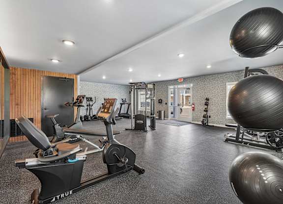 A gym with a variety of equipment including a rowing machine.