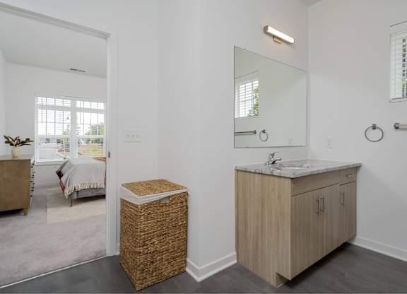 A bathroom with a wooden vanity and a mirror above it.