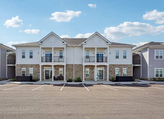 A row of houses with a parking lot in front.