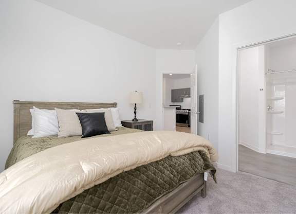 A bedroom with a bed, nightstand, and lamp.