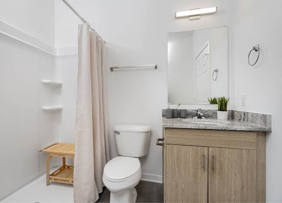 A white bathroom with a toilet, sink, and a mirror.