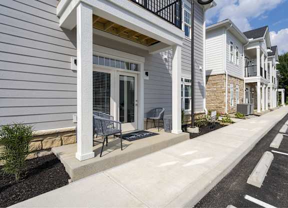 A row of houses with white siding and black railings.