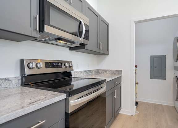 A modern kitchen with a stove top oven and microwave above it.