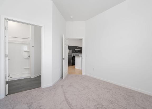 A room with a carpeted floor and a doorway leading to another room.