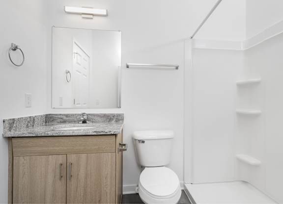 A white bathroom with a toilet, sink, and mirror.