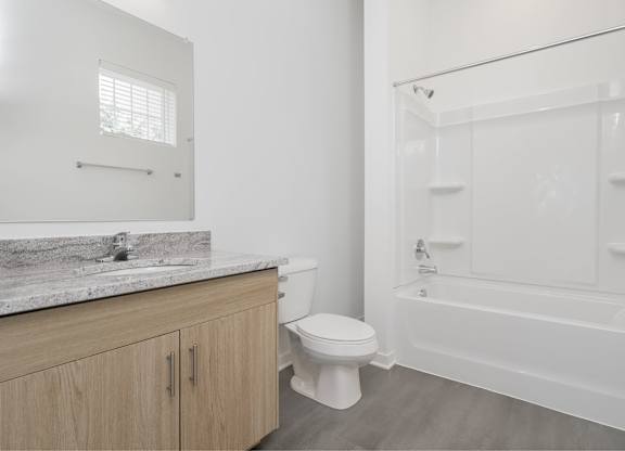 A white bathroom with a toilet, sink, and bathtub.