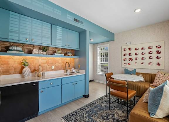 A kitchen with blue cabinets and a brown couch.