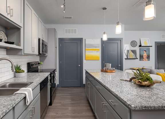 A kitchen with a sink, stove, and refrigerator.