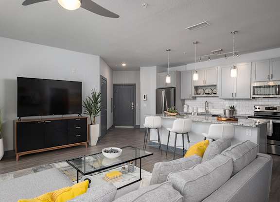 A modern living room with a grey sofa and a black television.