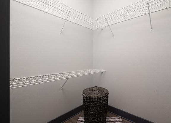 A room with a white wall and a black trash can.
