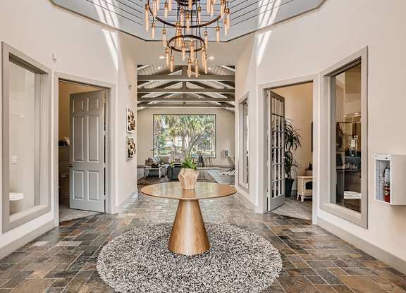A modern interior with a large table and a chandelier.