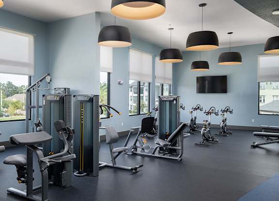 A gym with a variety of equipment including weights and cardio machines.