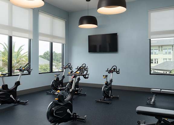 A gym with exercise bikes and a television.