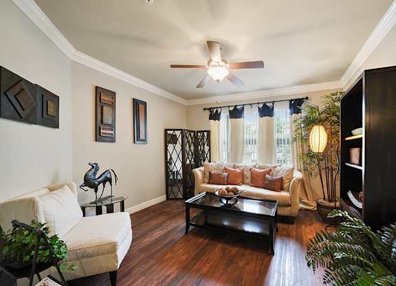 A living room with a white couch and a wooden floor.