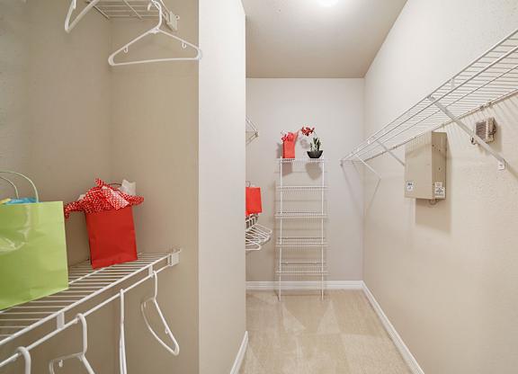 A white closet with a white shelf and a white hanger.
