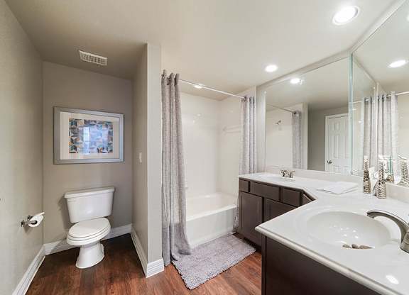 A bathroom with a white toilet, a white sink, and a white bathtub.