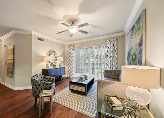 A living room with a chair, a table, and a painting on the wall.