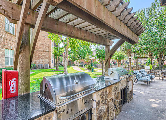 A patio with a grill and seating area.