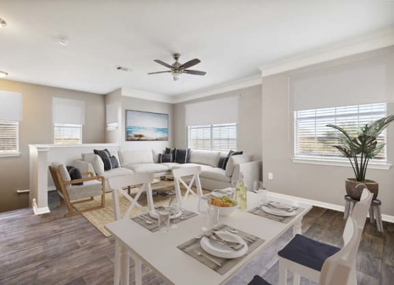 a living room filled with furniture and a ceiling fan