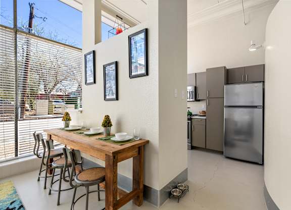 A kitchen with a table and chairs in front of a window.