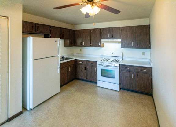 A kitchen with a white refrigerator and a white stove top oven.