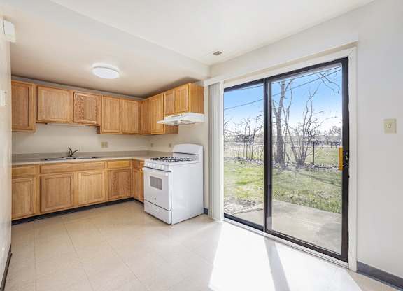 A kitchen with wooden cabinets and a white dishwasher.