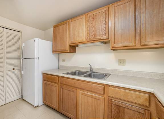 A kitchen with wooden cabinets and a white refrigerator.