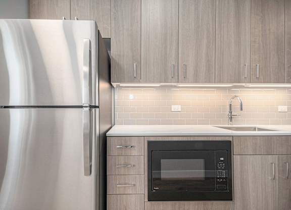 Kitchen with wood cabinets and stainless steel appliances at Thrive Exchange, Chicago