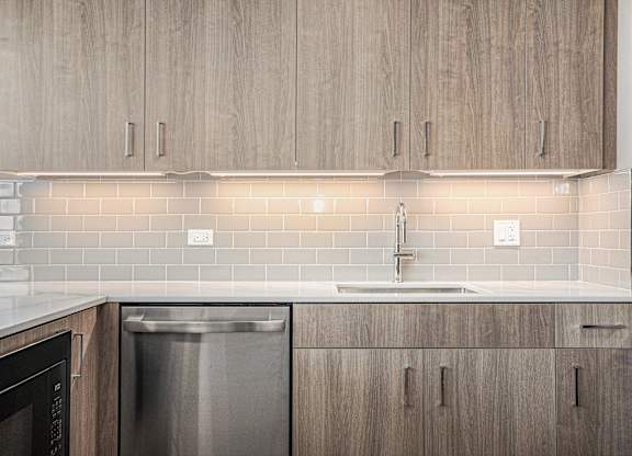 Stainless steel dishwasher and wooden cabinets in kitchen at Thrive Exchange, Chicago, IL