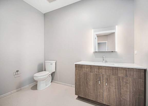 Toilet sits next to a sink in a bathroom at Thrive Exchange, Chicago, IL, Illinois